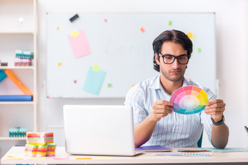 Young handsome male designer working in the office 