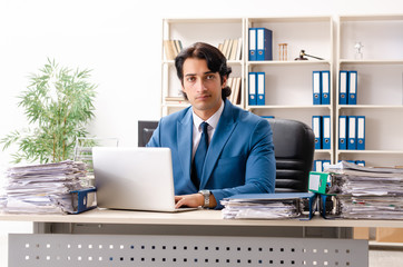 Young handsome busy employee sitting in office 