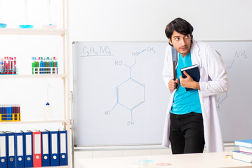 Young student chemist in the classroom 