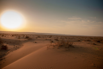 Fototapeta na wymiar A view of a big burning sun in the wide desert