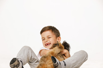 little boy is hugging the dog studio shot 