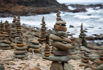 Pyramids from pebble on the sea coast. Little cairns on the background of the sea. Landscape for meditation.