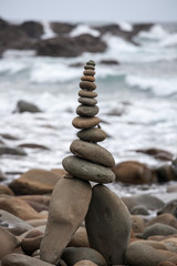 Pyramids from pebble on the sea coast. Little cairns on the background of the sea. Landscape for meditation.