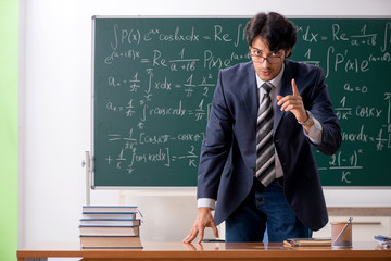 Young male math teacher in classroom 