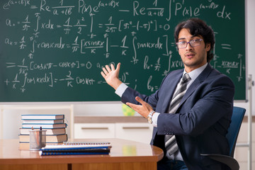 Young male math teacher in classroom 