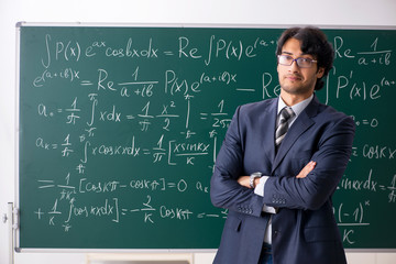Young male math teacher in classroom 