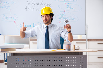 Young male architect in front of the whiteboard 