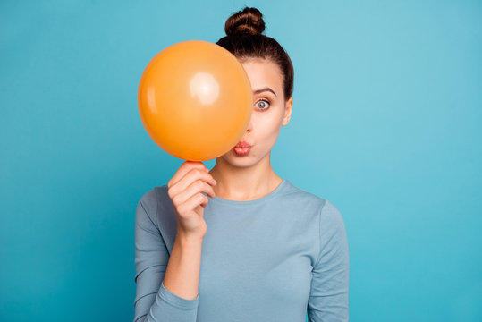 Close Up Photo Of Astonished Funy Lady Impressed Incredible News Holidays Fear Omg Unexpected Unbelievable Hide Orange Ballons Wear Modern Cotton Outfit Isolated On Blue Background 