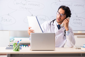 Young male doctor neurologist in front of whiteboard 