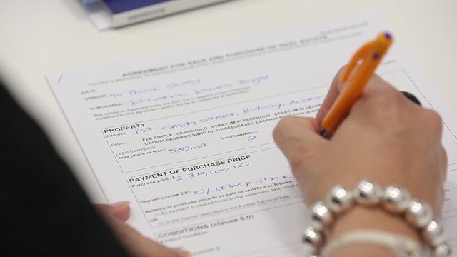 Close up of woman hands writing with a pen and filling a form