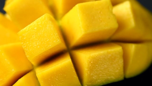 Rotation close-up of rip mango slice cubes cut in 4K resolution