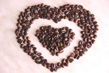 coffee beans in the shape of a heart in the heart, after roasting on the table, selective focus....