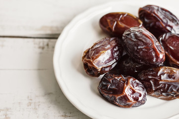 Dried dates on white plate. Healthy snack. Traditional dessert during Ramadan month