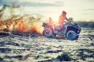 Teen riding ATV in sand dunes making a turn in the sand © 6okean