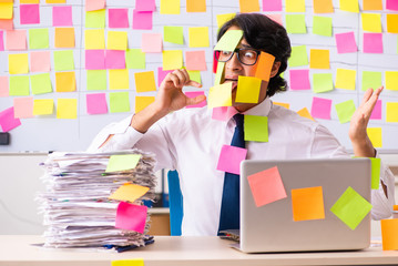 Young employee in conflicting priorities concept 