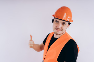Man in working uniform on white background Portrait of young male in bright orange protective hardhat and vest looking at camera on white background