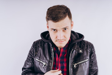 Man in trendy jacket on white background Portrait of young male in leather jacket zipping up and smiling at camera on white background