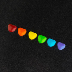 struggle for happiness and equality of sexual minorities: 6 multi-colored candy with the rainbow color of the LGBT flag, short focus, dark background