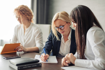 business, teamwork and women concept - female team of young caucasian women entrepreneurs working...