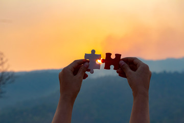 hands holding piece of red jigsaw puzzle. teamwork concept