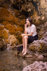 Beautiful girl posing in river, fairy fast forest in autumn.  Beauty, fashion. Spa, healthcare. Tropical vacation. Natural pool.