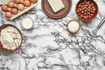 Fototapeta na wymiar Close-up shot. Top view of a baking ingredients and kitchenware on the marble table background.