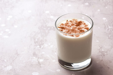 Glass of eggnog and candy cane.