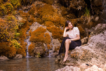 Beautiful girl posing in river, fairy fast forest in autumn.  Beauty, fashion. Spa, healthcare. Tropical vacation. Natural pool.