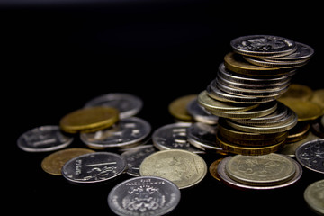 Coins stack on black background in concept wall and strong money.