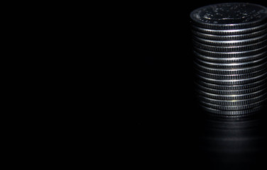 Coins stack on black background in concept wall and strong money.