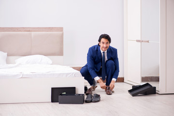 Young handsome businessman choosing shoes at home 