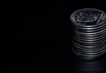 Coins stack on black background in concept wall and strong money.