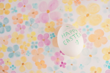 White chicken egg with a green inscription Happy Easter