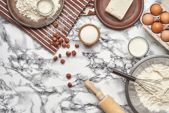 Close-up shot. Top view of a baking ingredients and kitchenware on the marble table background. © nazarovsergey