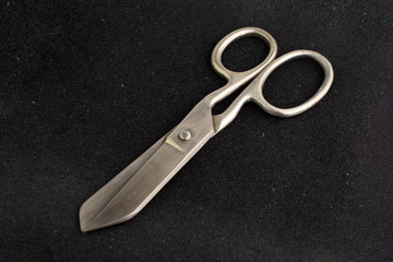 vintage big seamstress scissors isolated on black background. short focus