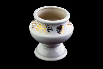 white porcelain aromatic lampada with a gold pattern on a black background, short focus