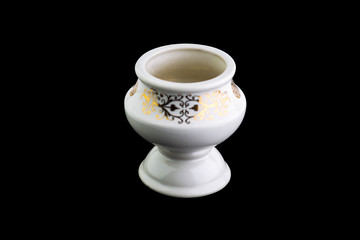 Obraz na płótnie Canvas white porcelain aromatic lampada with a gold pattern on a black background, short focus