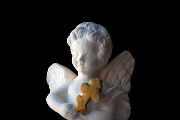 Valentine's Day, Christmas: Antique statuette of a white angel with a cross in his hands, isolated...