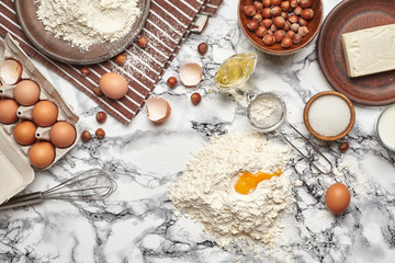 Close-up shot. Top view of a baking ingredients and kitchenware on the marble table background.