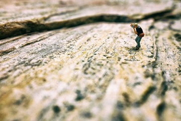 Close up Miniature People, Photographer taking a Photo on Concrete Ground.