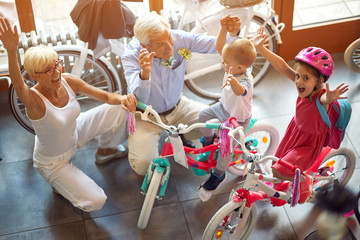 happy grandparents with grandchildren buying new bicycle top view.