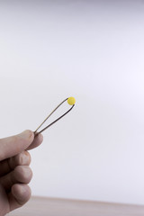 study of synthetic drugs: laboratory technician holds a sample of a new drug, light background, short focus