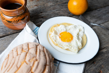 Mexican breakfast with egg, orange, sweet bread and coffee