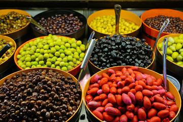 Colorful bowls of marinated olives at a food market