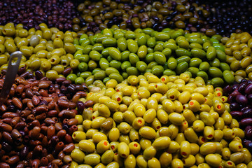 Colorful bowls of marinated olives at a food market