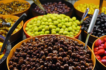 Colorful bowls of marinated olives at a food market