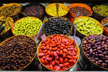 Colorful bowls of marinated olives at a food market