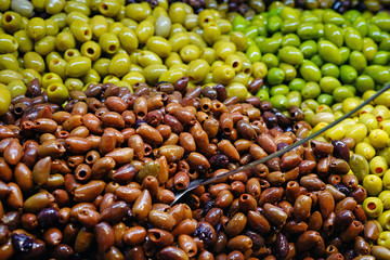 Colorful bowls of marinated olives at a food market