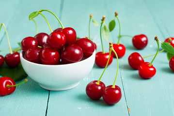 sour cherry fruits at bowl on old blue wood table