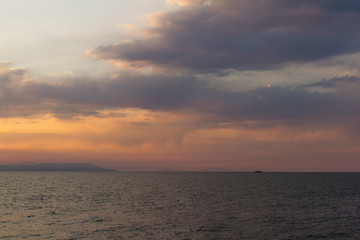 sunset on the sea and the boat in the distance